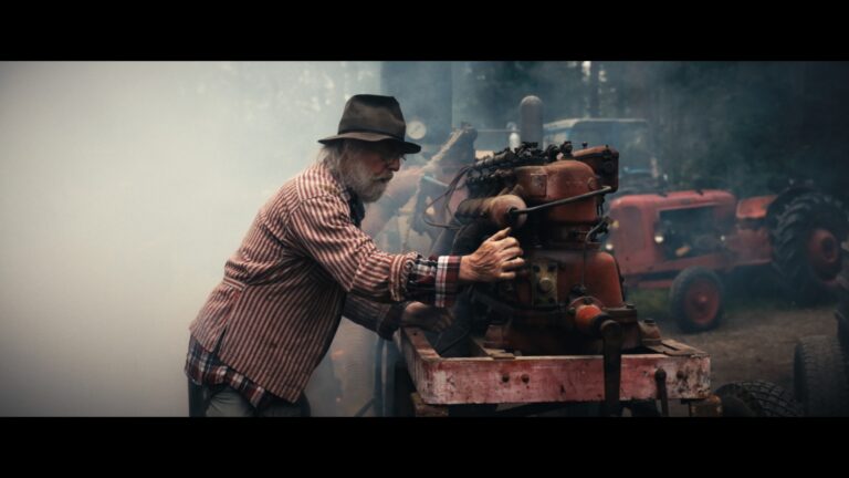 Närbild på rökpuffar och detaljer från en historisk maskin i arbete.